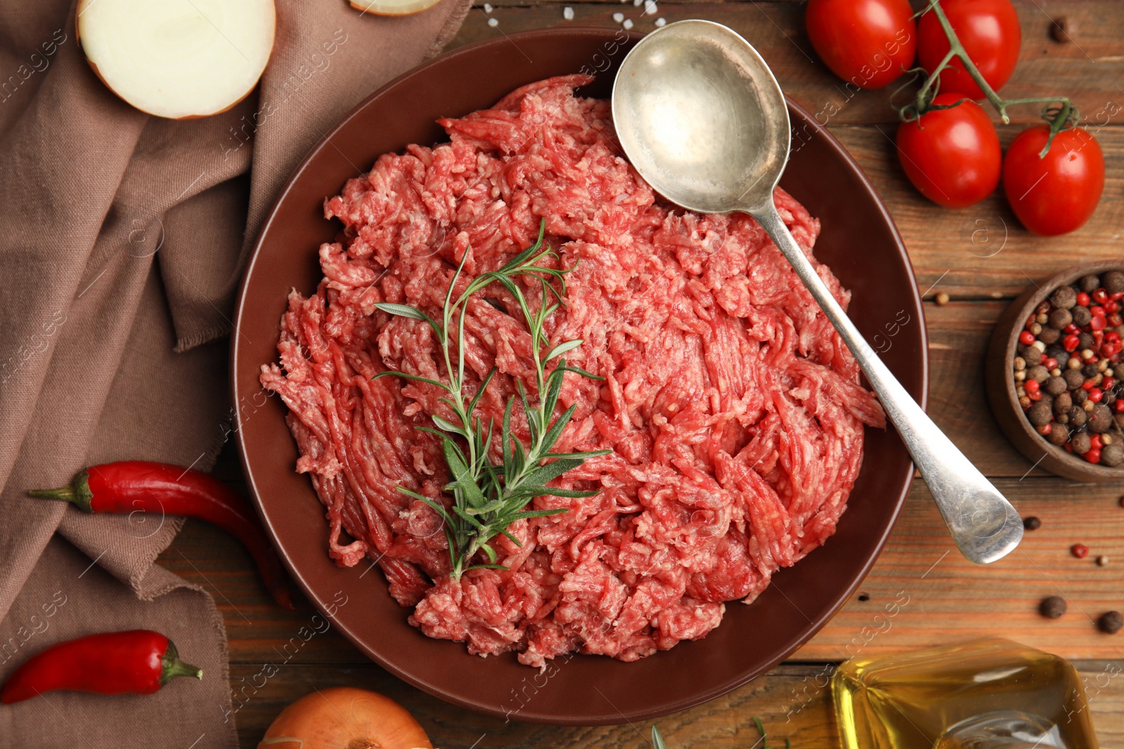 Photo of Fresh minced meat and other ingredients on wooden table, flat lay