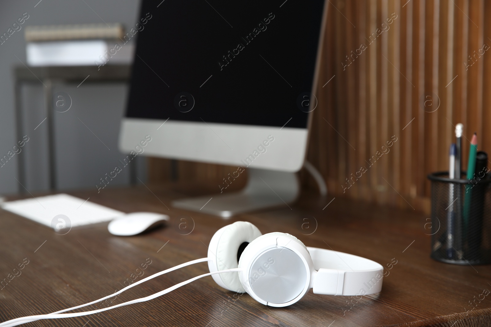 Photo of Stylish headphones on office table. Space for text