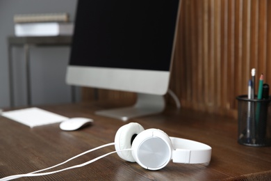 Photo of Stylish headphones on office table. Space for text