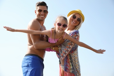 Photo of Family in beach clothes playing outdoors on sunny summer day