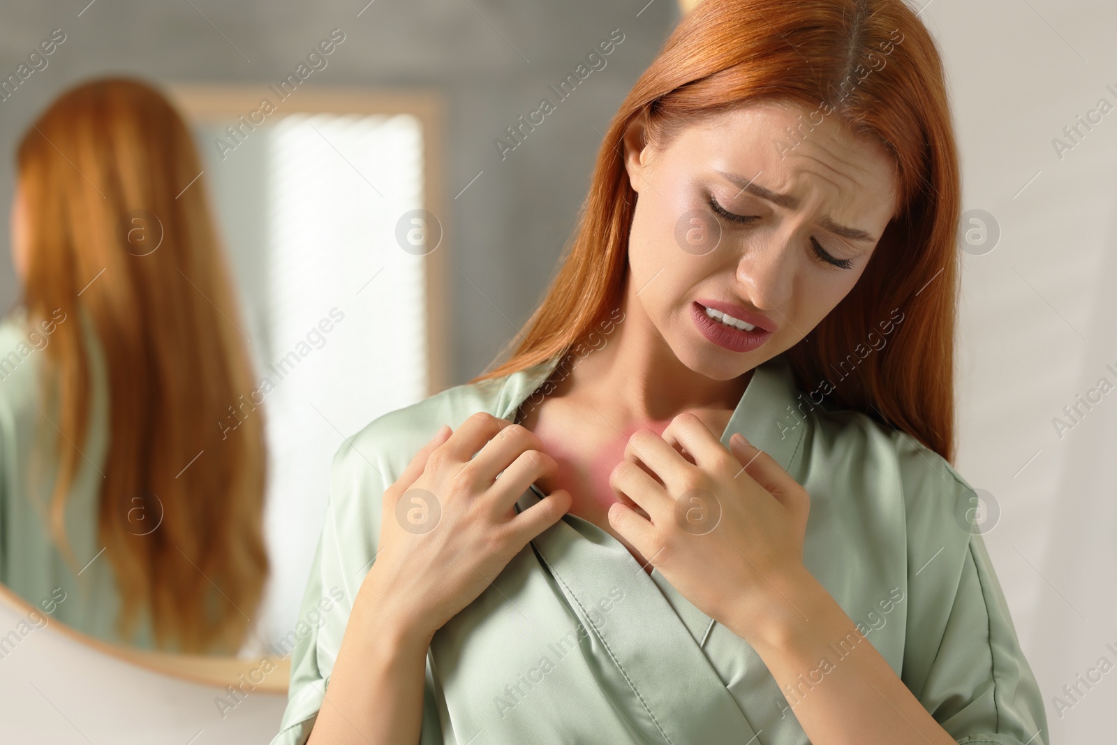 Photo of Suffering from allergy. Young woman scratching her neck in bathroom, space for text