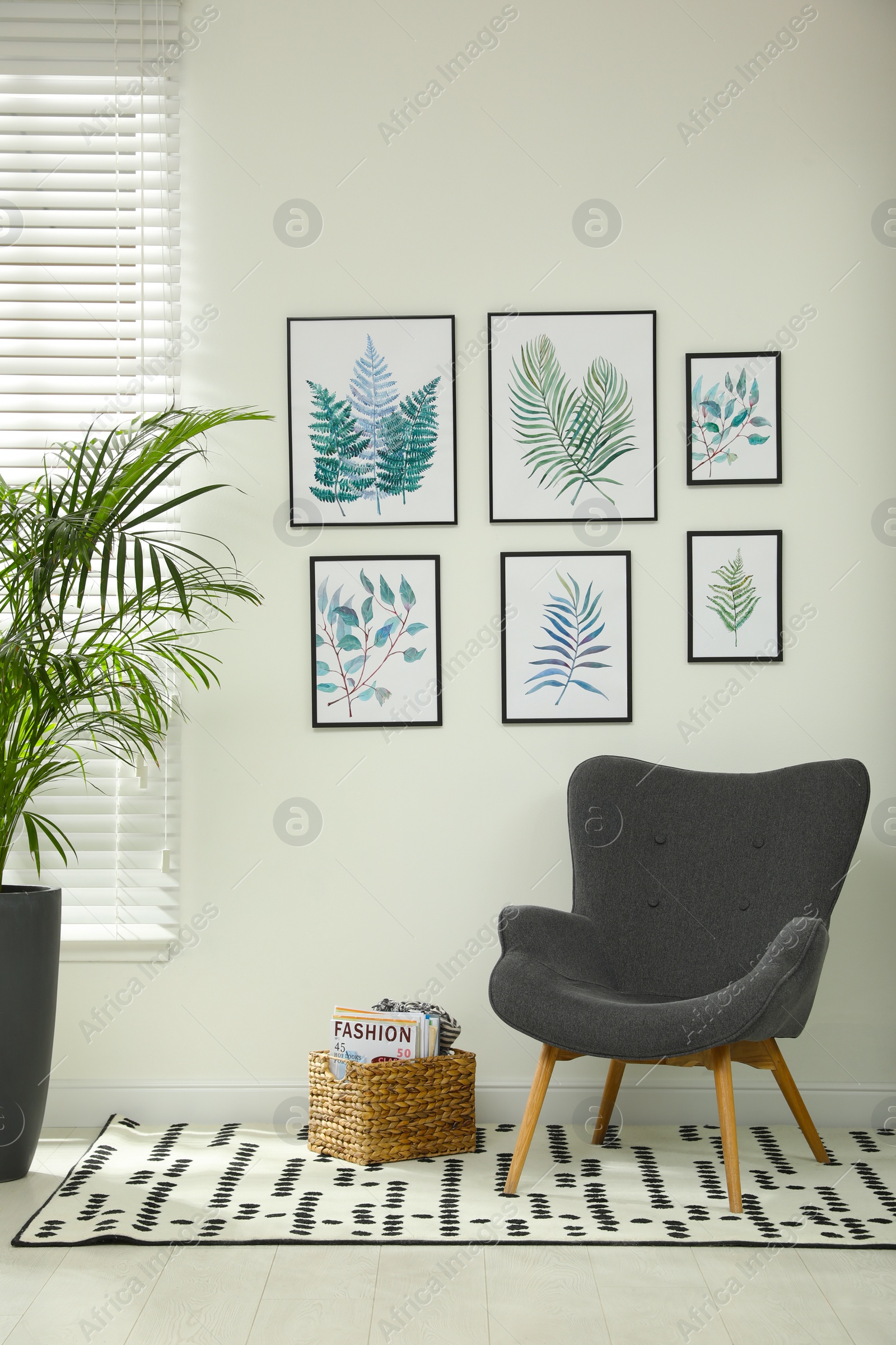 Photo of Beautiful paintings of tropical leaves on white wall in room interior