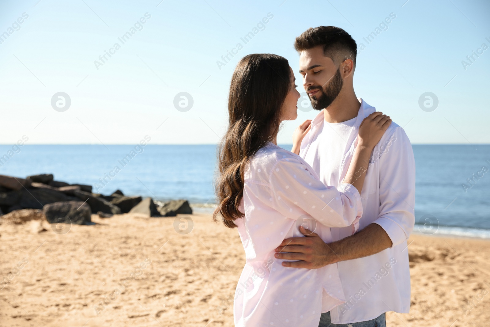 Photo of Happy young couple on beach near sea. Honeymoon trip