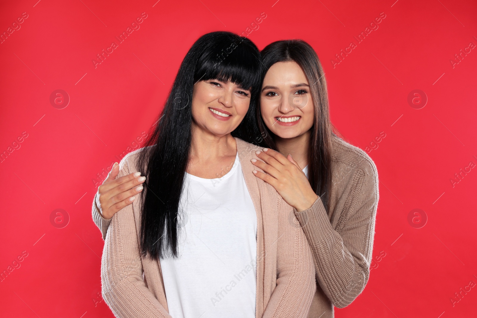 Photo of Portrait of young woman and her mature mother on color background