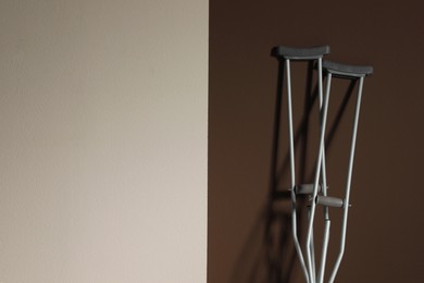 Photo of Pair of axillary crutches on color background. Space for text