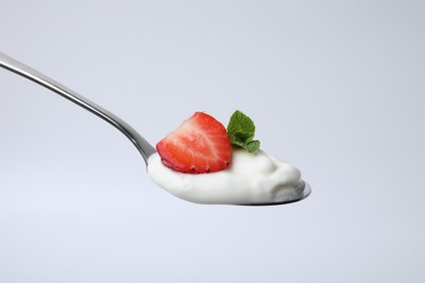 Photo of Spoon with yogurt, strawberry and mint isolated on white