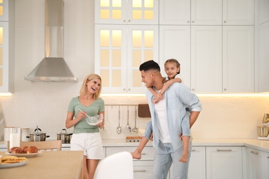 Photo of Happy family cooking together in modern kitchen