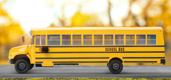 Image of Yellow school bus on road outdoors. Transport for students