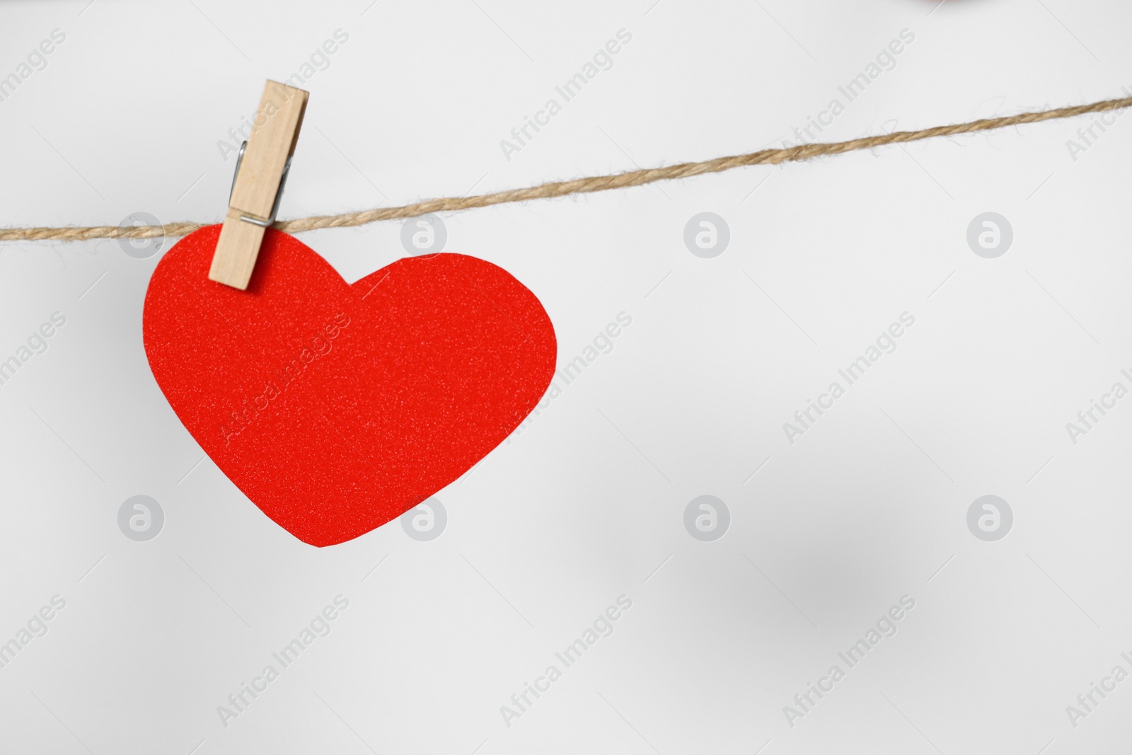 Photo of Decorative heart hanging on twine against white background, space for text. Valentine's Day