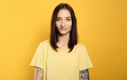 Portrait of pretty young woman with gorgeous chestnut hair on yellow background