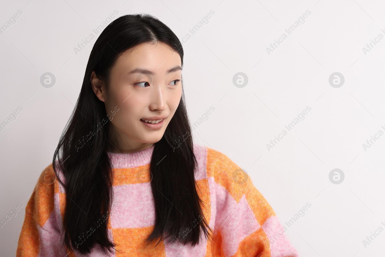 Photo of Portrait of smiling woman on light background. Space for text