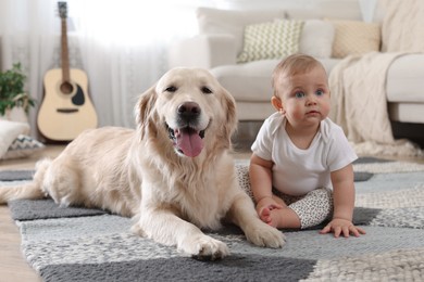 Photo of Cute little baby with adorable dog on floor at home