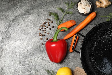 Empty iron wok and raw ingredients on grey table, flat lay. Space for text