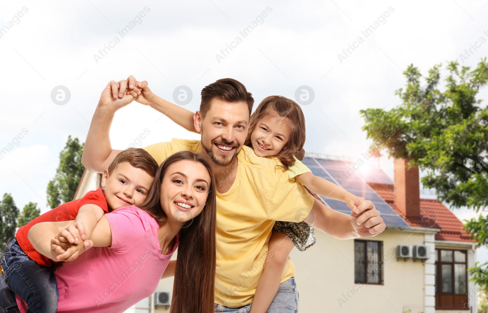 Image of Happy family near their house with solar panels. Alternative energy source