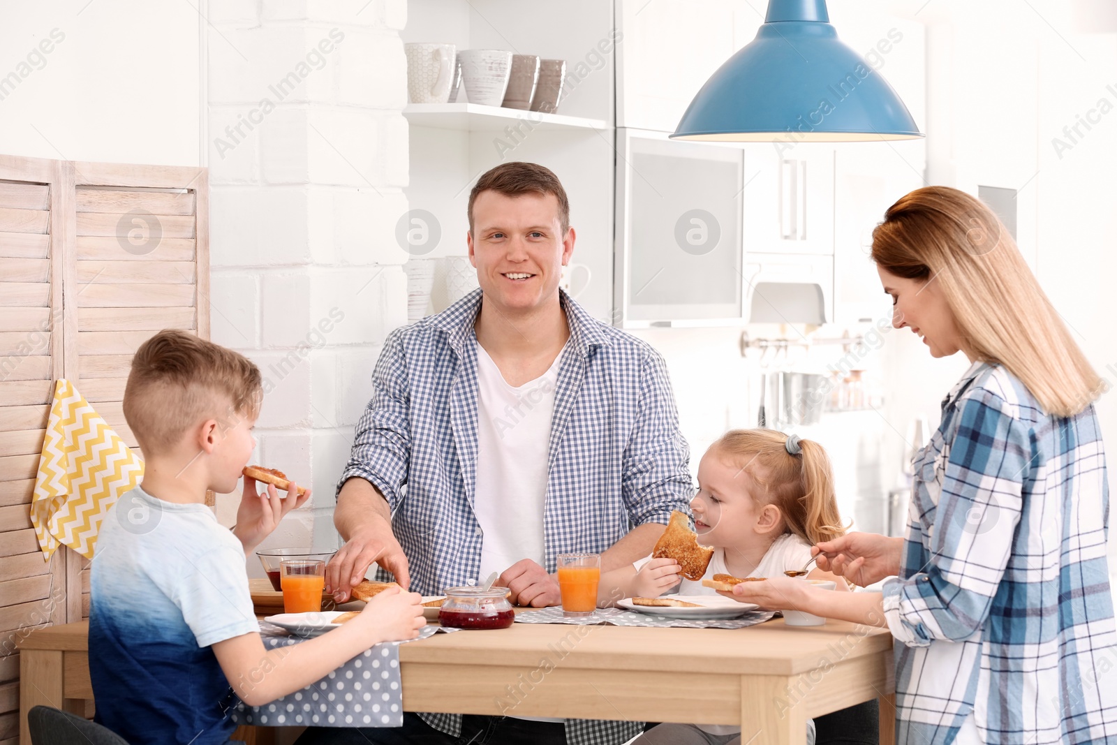 Photo of Parents and cute little children having breakfast with tasty toasted bread at table