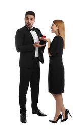 Photo of Young woman with engagement ring making marriage proposal to her boyfriend on white background