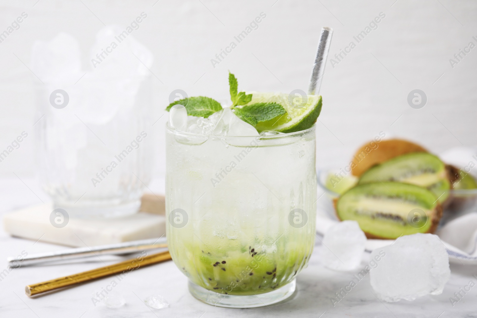 Photo of Glass of refreshing drink with kiwi, lime and mint on white table, closeup