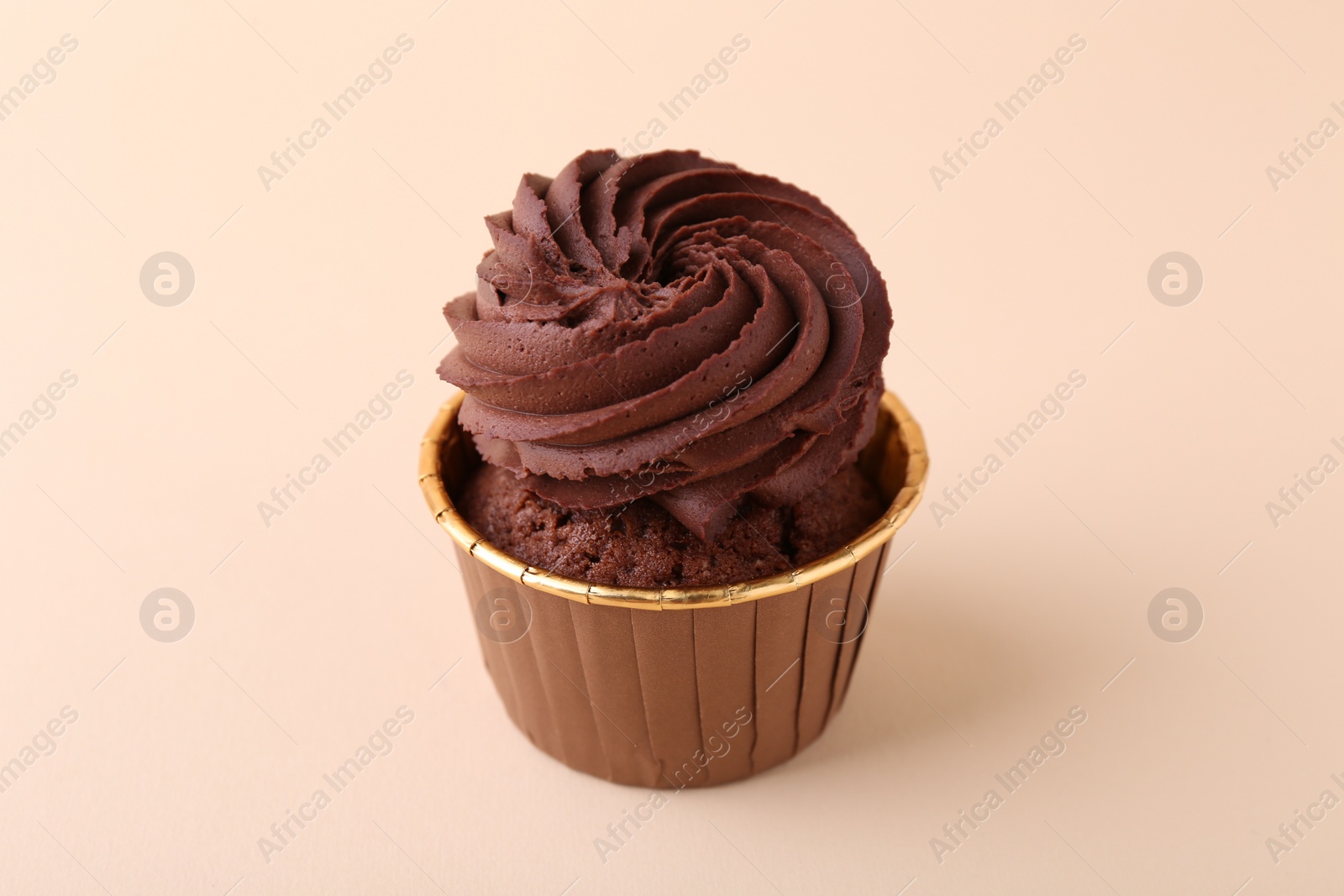 Photo of Delicious chocolate cupcake on beige background, closeup