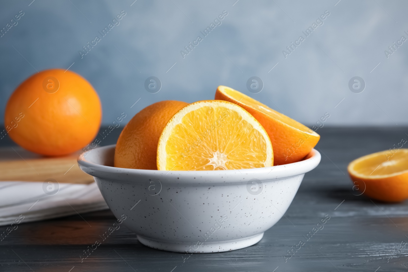 Photo of Fresh oranges in bowl on wooden table