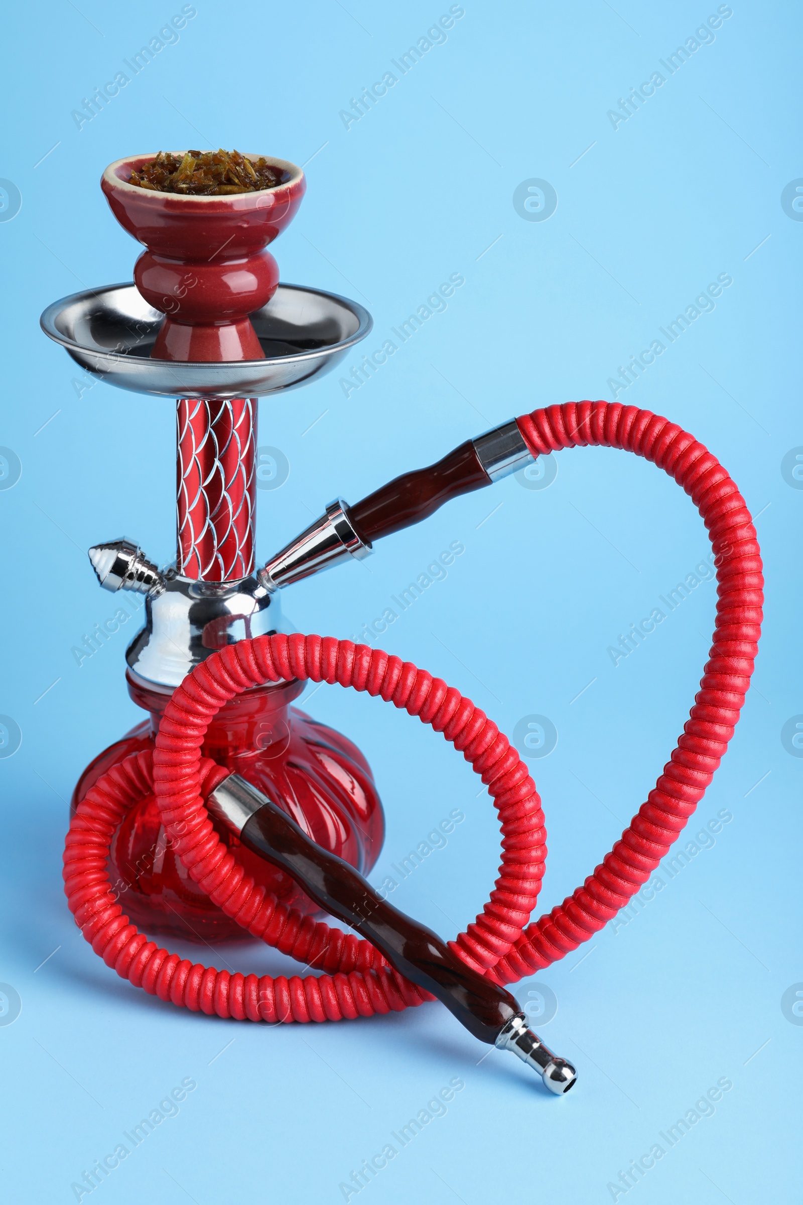 Photo of Modern red hookah on light blue background