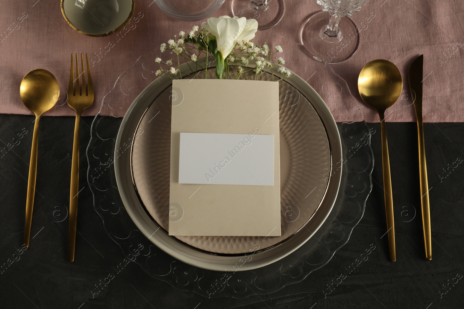 Photo of Stylish table setting. Dishes, cutlery, blank card and floral decor, flat lay