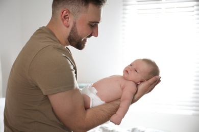 Photo of Father with his newborn son at home