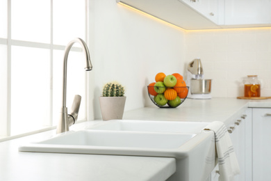 Ceramic sink and modern tap in stylish kitchen interior