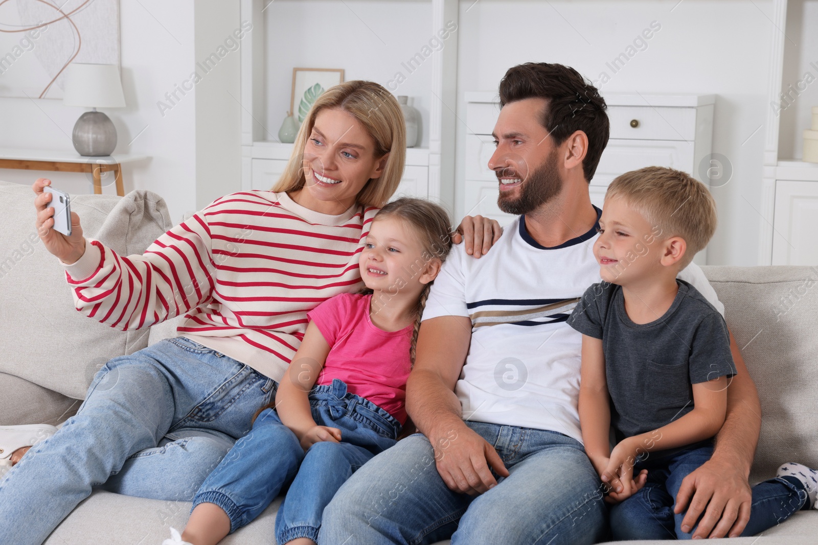 Photo of Happy family taking selfie together on sofa at home