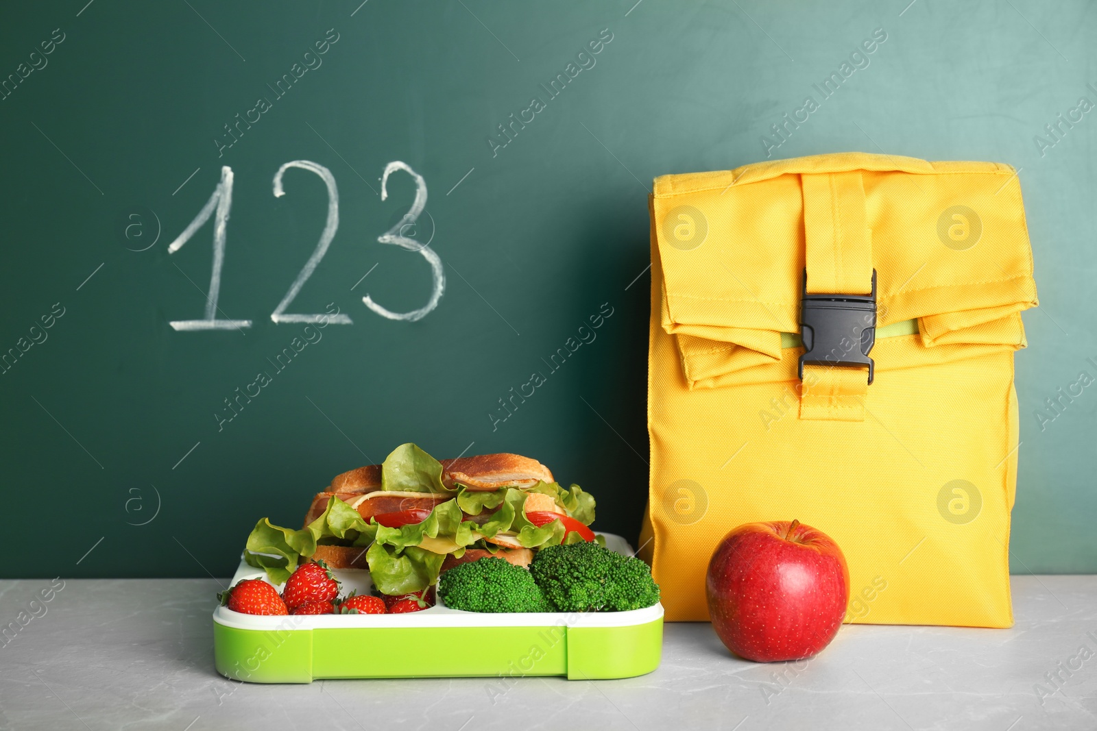 Photo of Healthy food for school child on table near chalkboard with written numbers