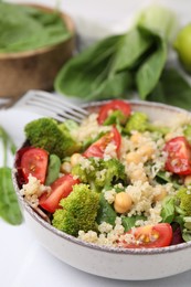Photo of Healthy meal. Tasty salad with quinoa, chickpeas and vegetables served on white table, closeup