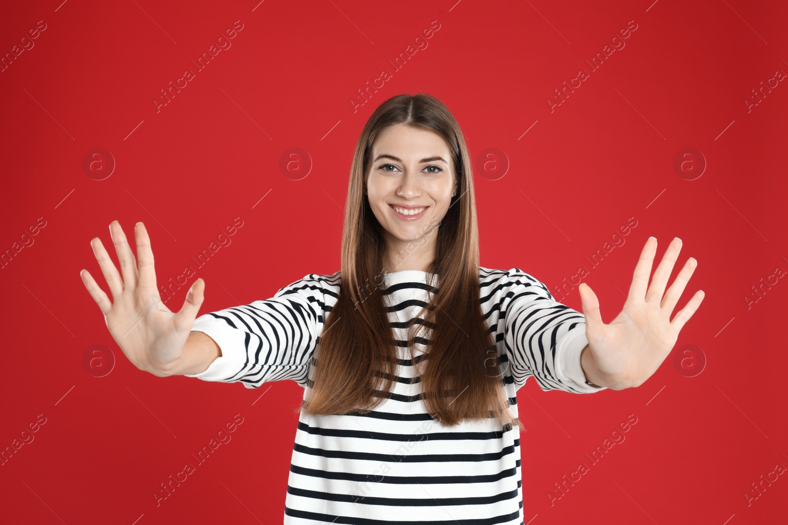 Photo of Woman showing number ten with her hands on red background