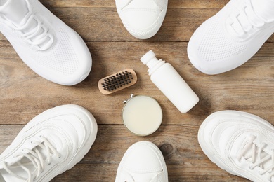 Photo of Flat lay composition with stylish footwear and shoe care accessories on wooden background