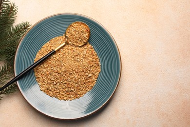 Plate with dried orange seasoning zest on beige textured table, top view. Space for text