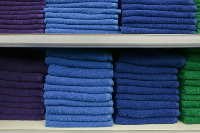 Stacks of colourful towels on store shelves