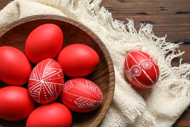 Flat lay composition with painted red Easter eggs on wooden table