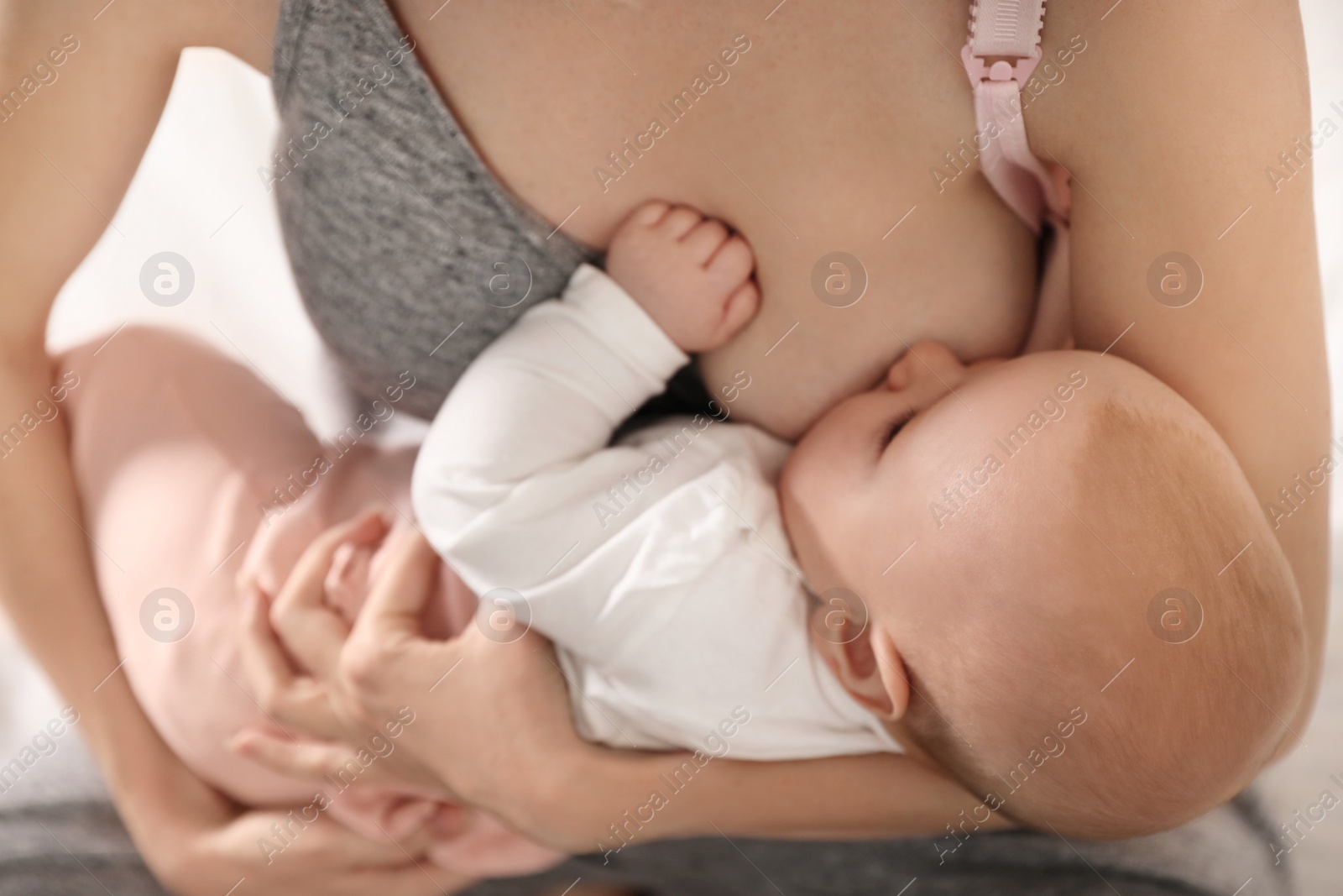 Photo of Young woman breast feeding her little baby, closeup