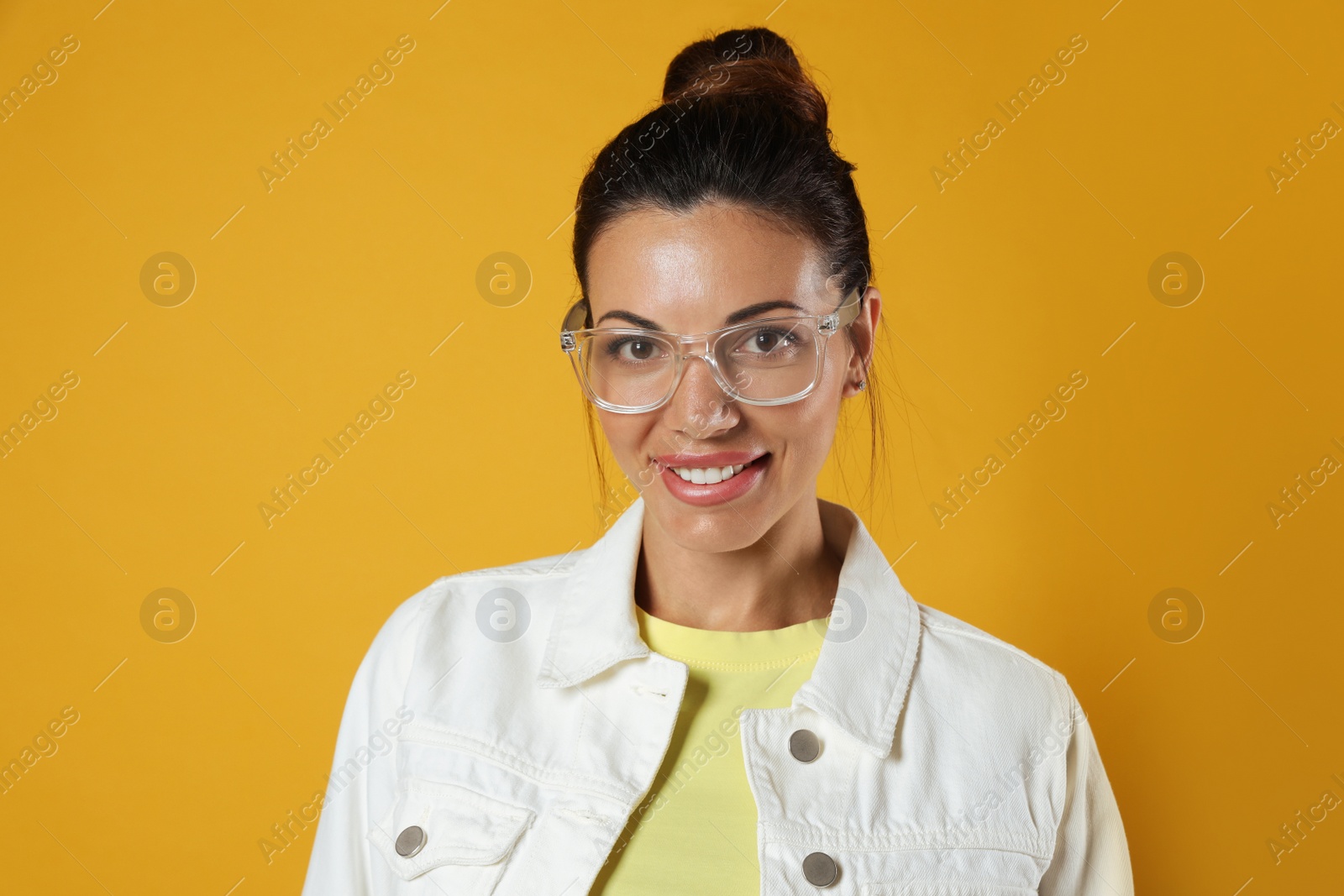 Photo of Beautiful woman in eyeglasses on yellow background