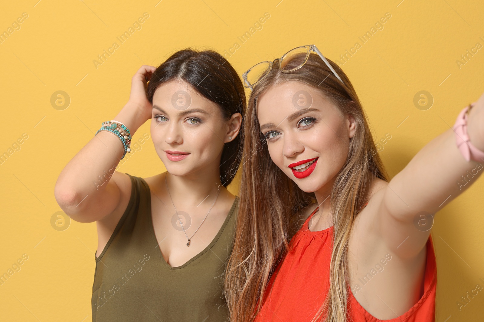 Photo of Attractive young women taking selfie on color background