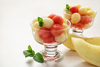 Photo of Melon and watermelon balls with mint served on light table
