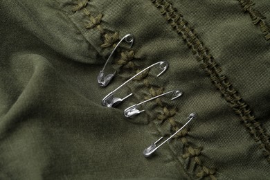 Photo of Top view of metal safety pins on clothing