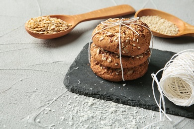 Photo of Slate plate with grain cereal cookies on table. Healthy snack