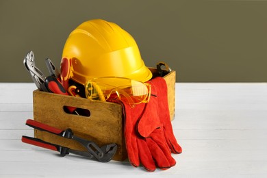 Photo of Wooden box with different tools for repair on white table, space for text