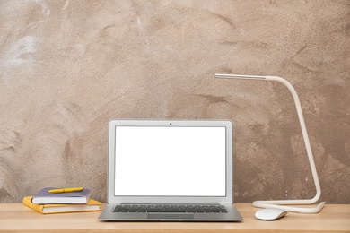 Laptop on desk against color wall in home office. Comfortable workplace