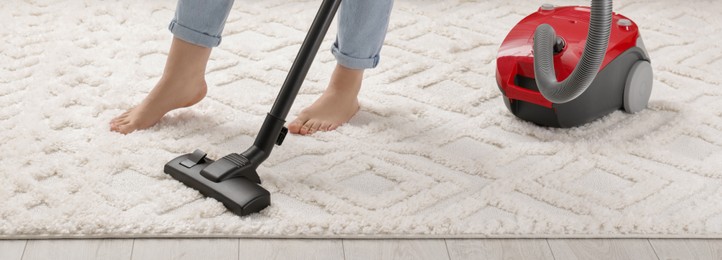 Image of Woman cleaning carpet with vacuum cleaner at home, closeup. Banner design