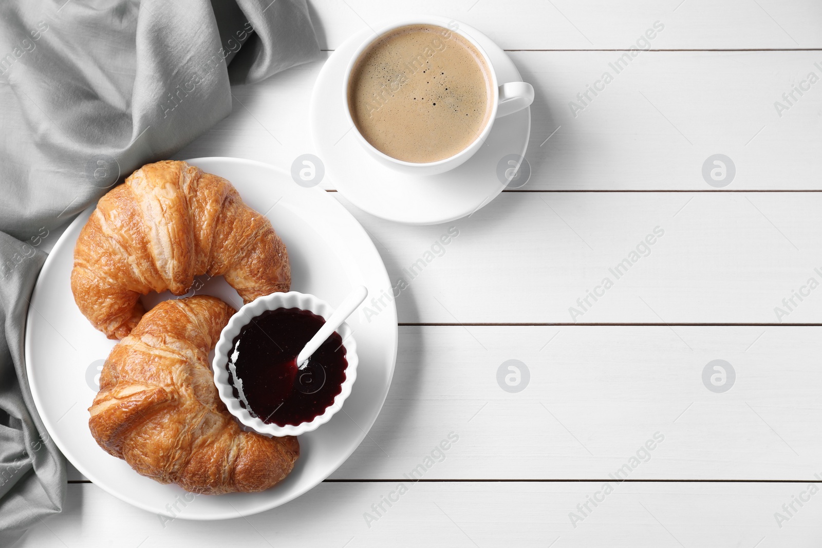 Photo of Breakfast time. Fresh croissants, jam and coffee on white wooden table, flat lay. Space for text