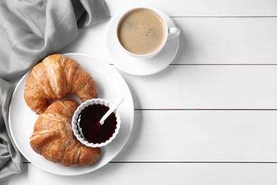 Photo of Breakfast time. Fresh croissants, jam and coffee on white wooden table, flat lay. Space for text