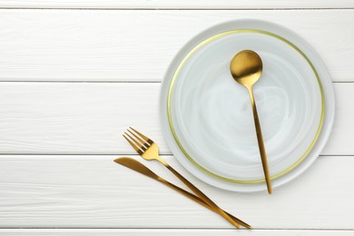 Photo of Stylish setting with cutlery and plate on white wooden table, flat lay. Space for text