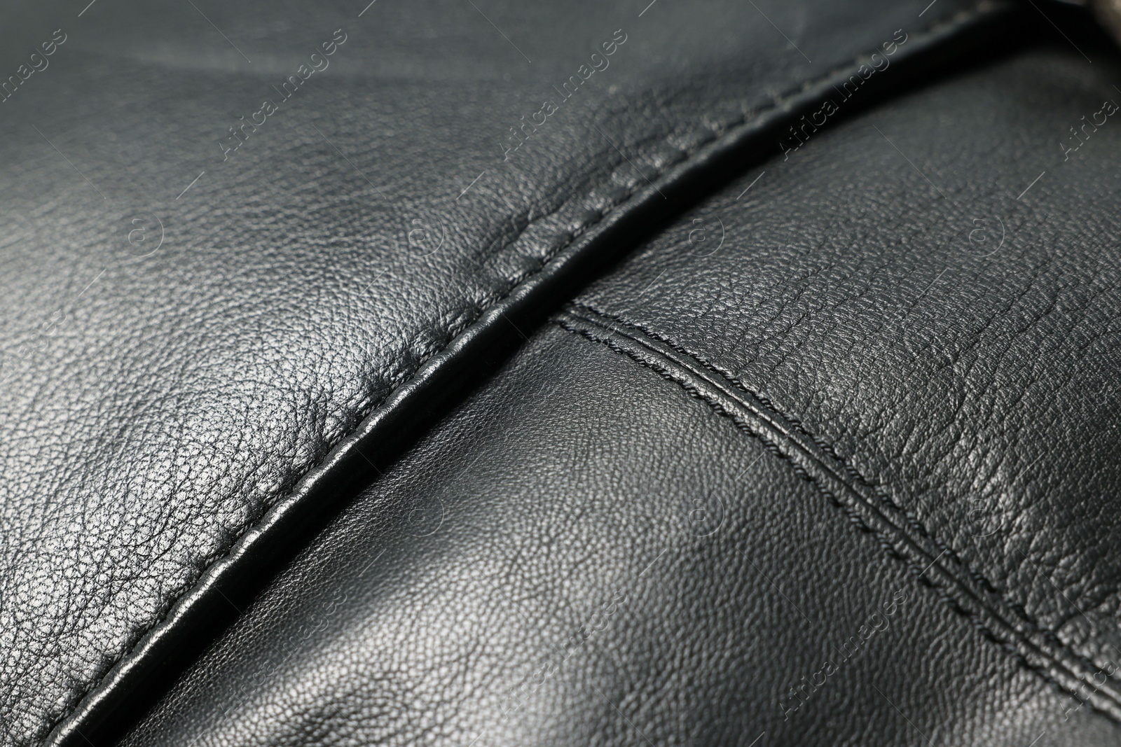 Photo of Black natural leather with seams as background, closeup