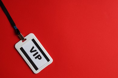 Photo of Plastic vip badge on red background, top view. Space for text