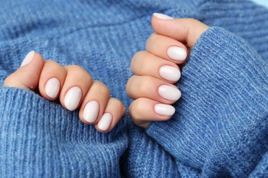 Photo of Woman showing her manicured hands with white nail polish, closeup